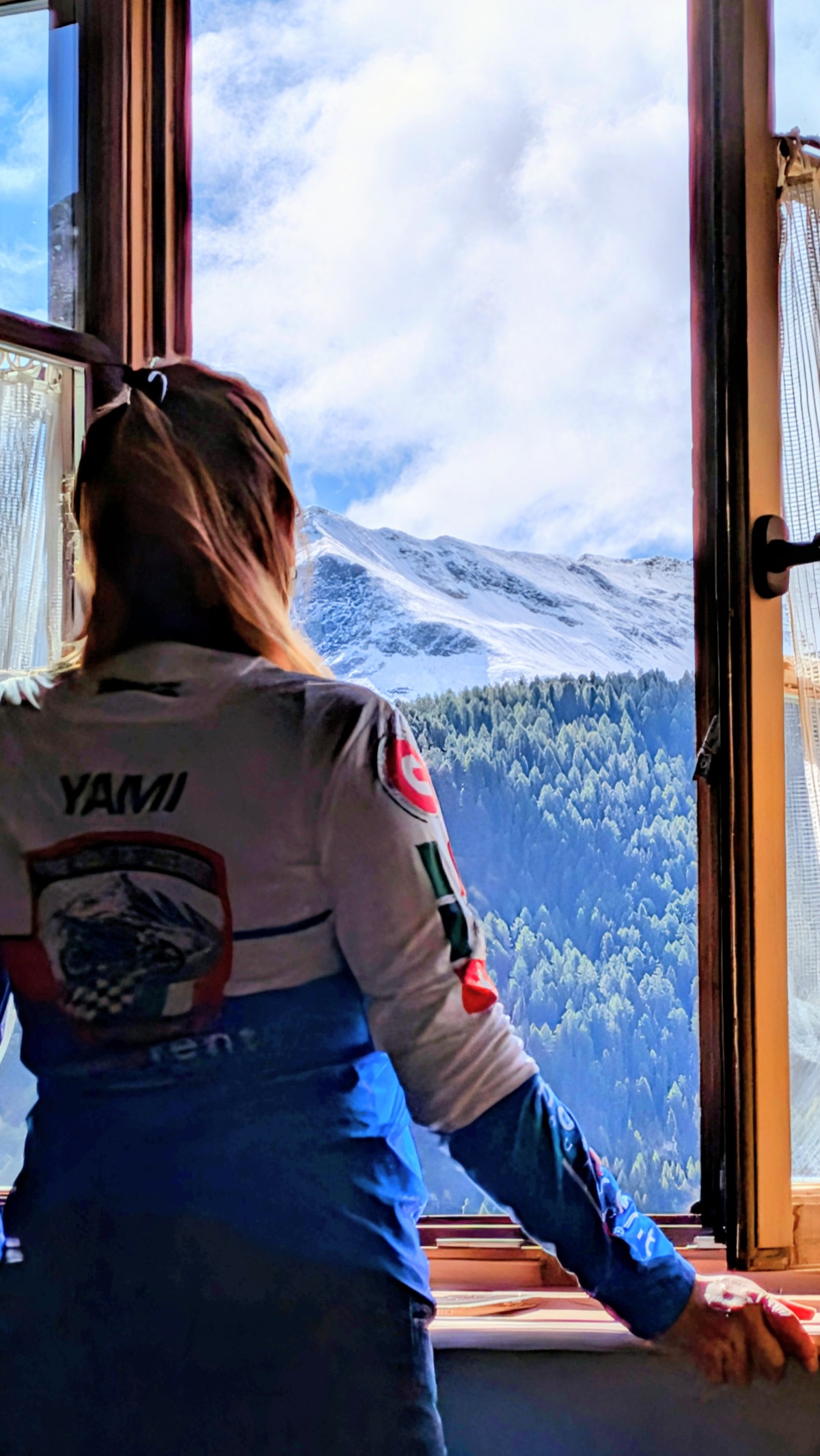 Yamila contempla las montañas desde la ventana del hotel